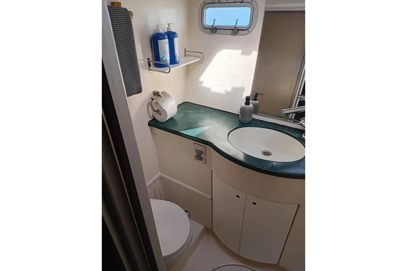  Yacht Photos Pics Bathroom interior of 1995 Fountaine Pajot Marquises 56 yacht, featuring sink and toilet.