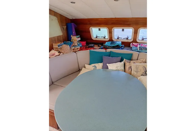  Yacht Photos Pics Cozy interior of 1995 Fountaine Pajot Marquises 56 with cushions and books.
