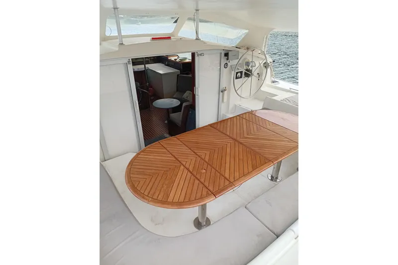  Yacht Photos Pics Cockpit view of 1995 Fountaine Pajot Marquises 56 with wooden table and helm.