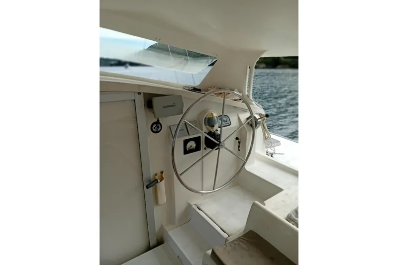  Yacht Photos Pics Steering wheel of 1995 Fountaine Pajot Marquises 56 catamaran, overlooking serene waters.