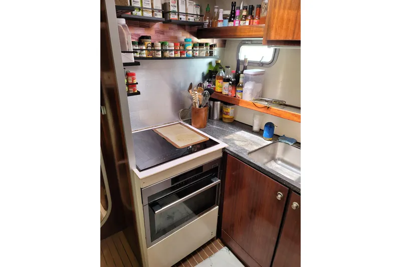  Yacht Photos Pics Compact kitchen in a 1995 Fountaine Pajot Marquises 56 yacht with stove, spices, and sink.