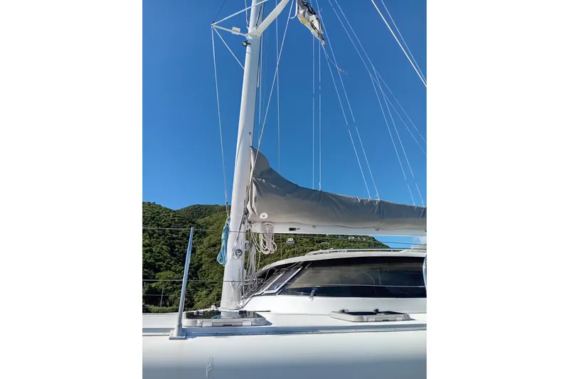 Yacht Photos Pics Sailboat mast and boom of 1995 Fountaine Pajot Marquises 56 against clear blue sky.