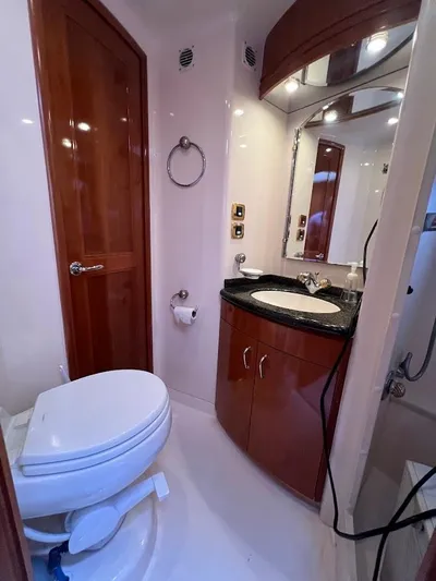 Roweboat Yacht Photos Pics Luxurious bathroom in 2006 Carver 56 Voyager yacht with wooden cabinetry and modern fixtures.