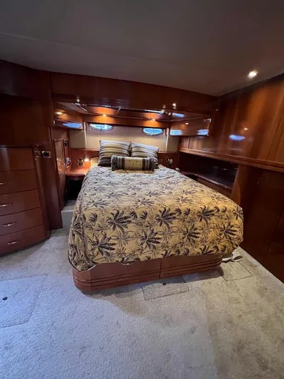 Roweboat Yacht Photos Pics Luxurious bedroom interior of 2006 Carver 56 Voyager yacht with elegant wood finish.