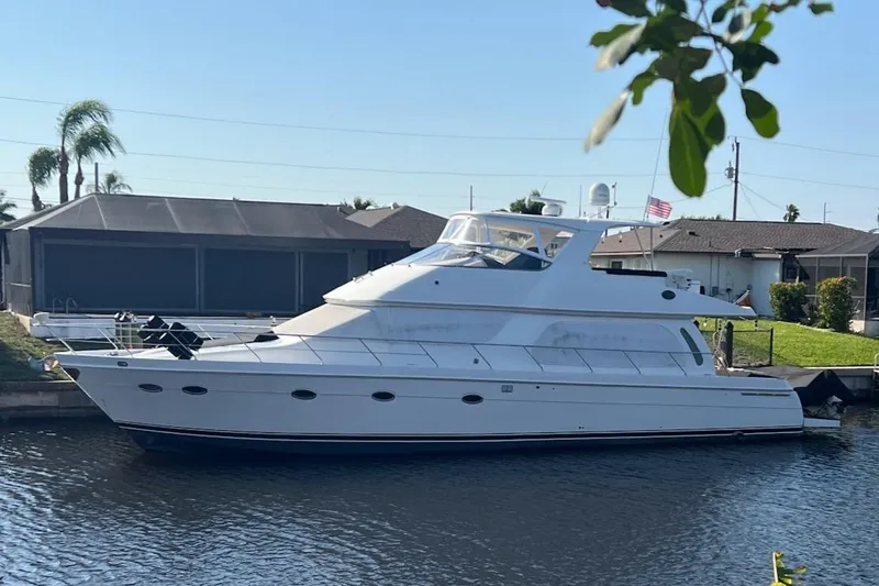 Roweboat Yacht Photos Pics 2006 Carver 56 Voyager yacht docked by a waterfront home.