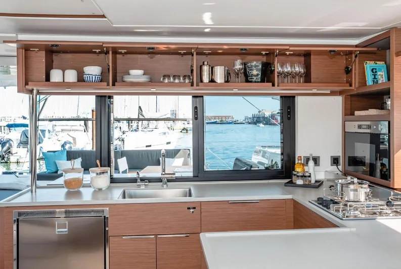 Martina Yacht Photos Pics Modern kitchen interior on 2021 Lagoon 46 catamaran with ocean view through large windows.