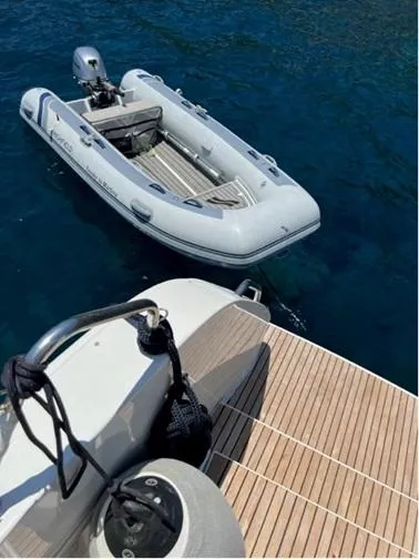 Martina Yacht Photos Pics Inflatable dinghy moored beside Lagoon 46 yacht, 2021 model, on clear blue water.
