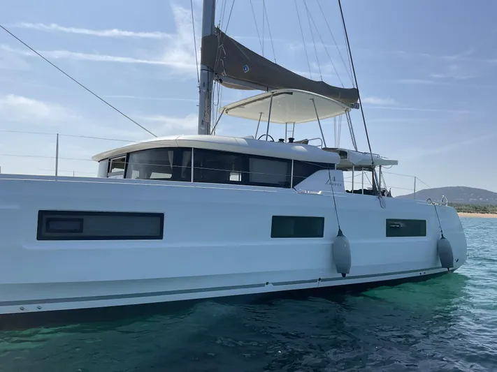 Martina Yacht Photos Pics 2021 Lagoon 46 catamaran sailing on clear blue water under a sunny sky.