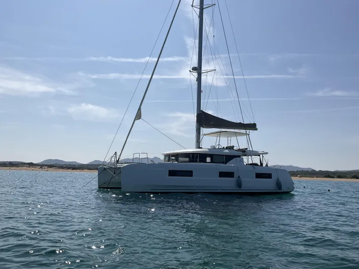 Martina Yacht Photos Pics 2021 Lagoon 46 catamaran sailing on calm waters under a clear sky.