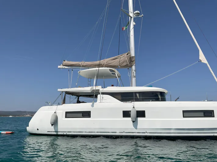 Martina Yacht Photos Pics 2021 Lagoon 46 catamaran sailing on calm blue waters under clear skies.