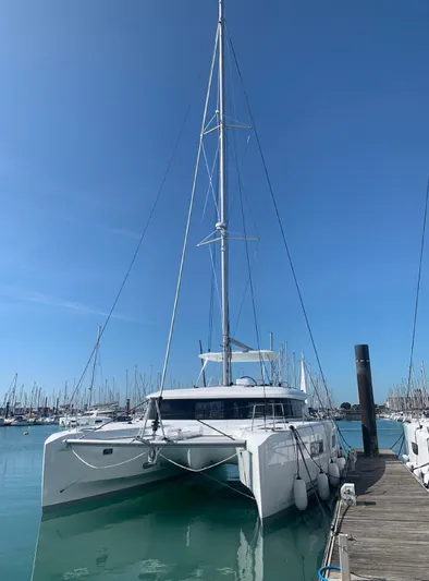 Martina Yacht Photos Pics 2021 Lagoon 46 catamaran docked at marina under clear blue sky.