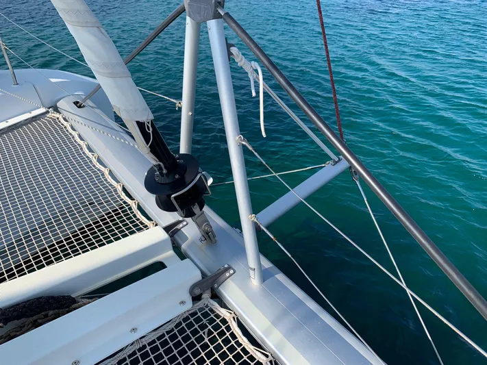 Martina Yacht Photos Pics 2021 Lagoon 46 catamaran deck with netting over clear blue water.