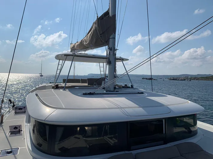 Martina Yacht Photos Pics 2021 Lagoon 46 catamaran sailing on a sunny day with clear skies and calm waters.