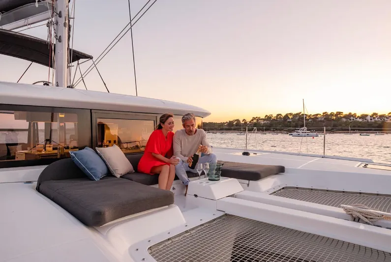 Martina Yacht Photos Pics Couple relaxing on Lagoon 46 yacht at sunset, 2021 model, enjoying drinks on deck.