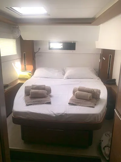Martina Yacht Photos Pics Luxurious cabin interior of 2021 Lagoon 46 yacht with neatly arranged bed and towels.