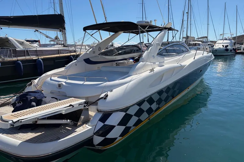  Yacht Photos Pics 2004 Sunseeker Superhawk 50 yacht docked in a marina, featuring sleek design and checkered detailing.