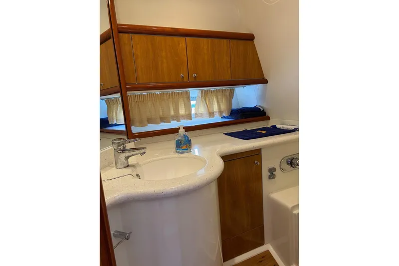  Yacht Photos Pics 2004 Sunseeker Superhawk 50 yacht bathroom with wooden cabinets and modern sink.