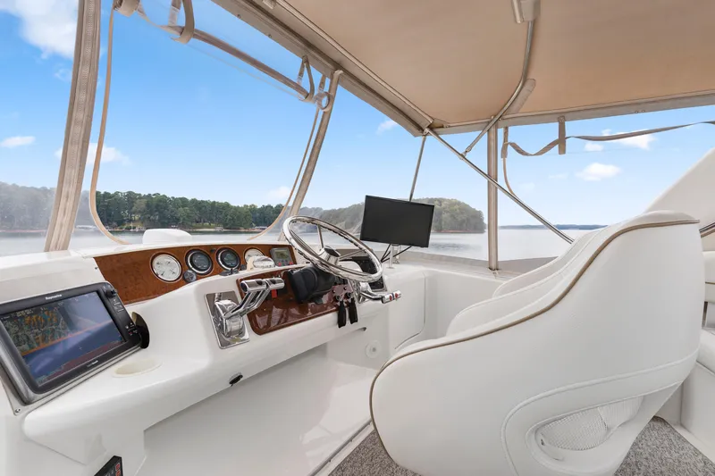 Water Cave Yacht Photos Pics 2005 Silverton 34 Convertible helm with modern controls and scenic water view.