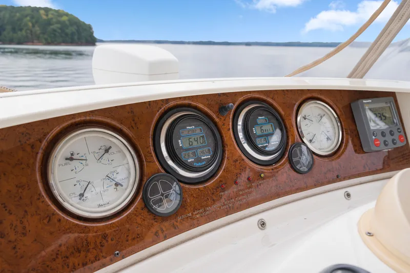 Water Cave Yacht Photos Pics Dashboard of 2005 Silverton 34 Convertible boat with gauges and controls, overlooking serene water.