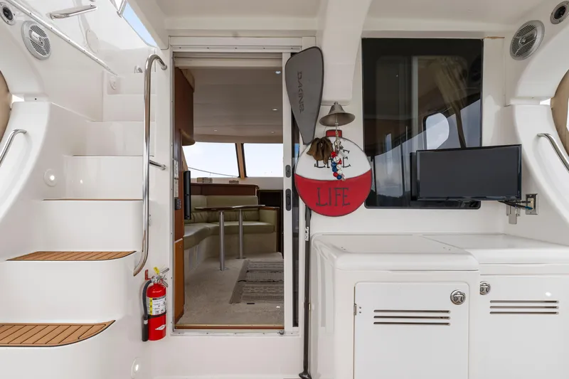 Water Cave Yacht Photos Pics 2005 Silverton 34 Convertible yacht interior with stairs, seating, and mounted TV.