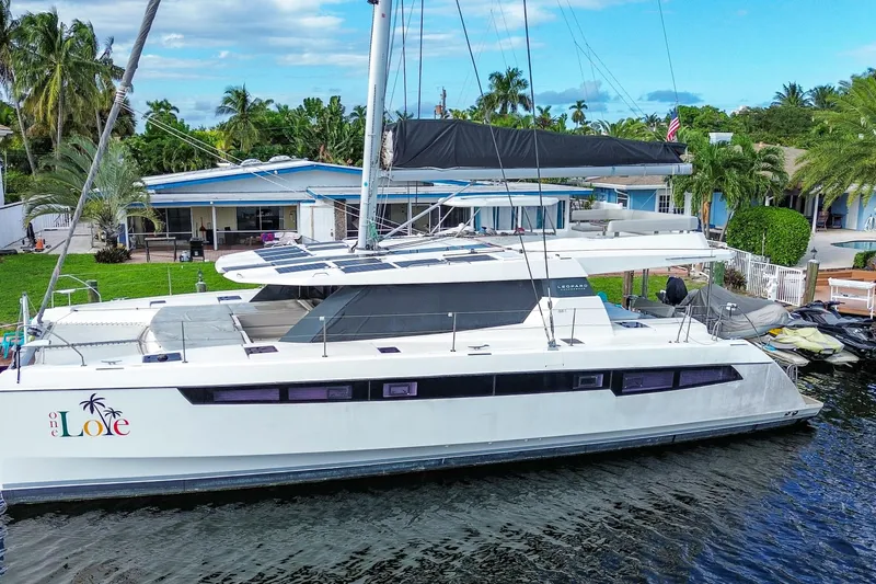 One Love Yacht Photos Pics 2019 Leopard 50 catamaran docked by a tropical waterfront home.