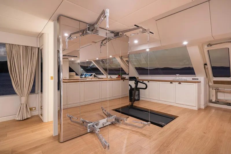  Yacht Photos Pics Luxurious interior of 2026 Sunreef 100 Power yacht with modern gym equipment and panoramic windows.