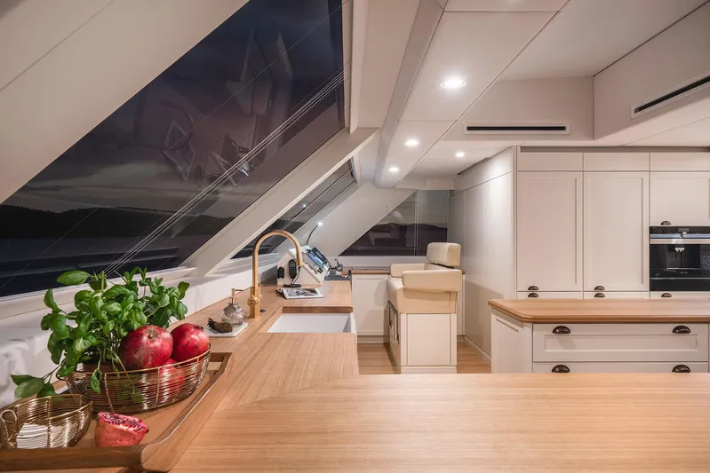  Yacht Photos Pics Luxurious kitchen interior of 2026 Sunreef 100 Power yacht with modern design and wooden accents.