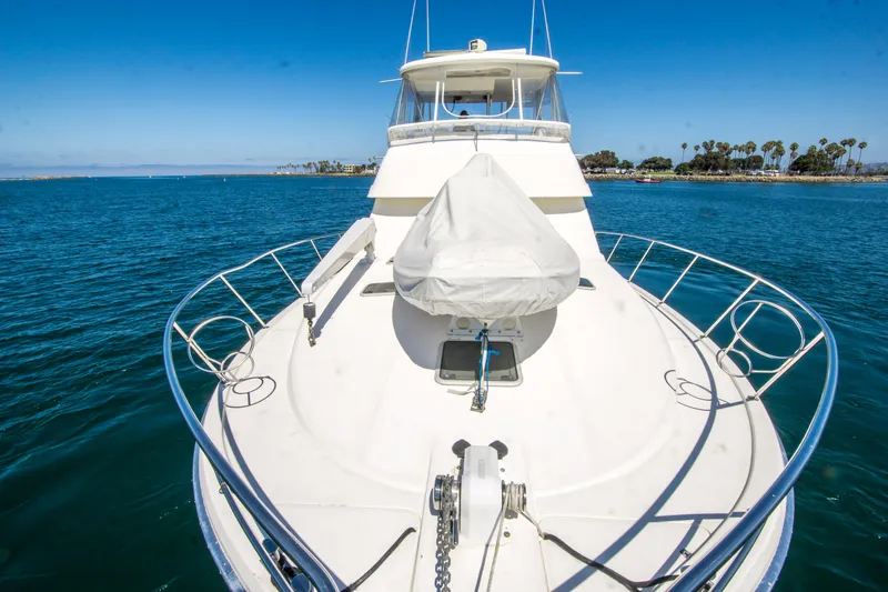 Play’n Hooky Yacht Photos Pics 1999 Riviera 43 Open Flybridge yacht on calm blue water, clear sky background.