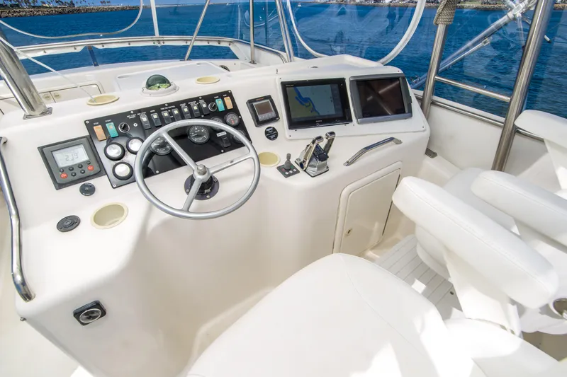 Play’n Hooky Yacht Photos Pics 1999 Riviera 43 Open Flybridge helm with steering wheel, controls, and navigation screens.