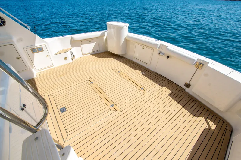 Play’n Hooky Yacht Photos Pics Spacious deck of 1999 Riviera 43 Open Flybridge yacht with teak flooring, overlooking blue ocean.