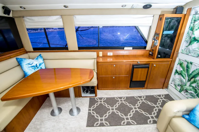 Play’n Hooky Yacht Photos Pics Interior of 1999 Riviera 43 Open Flybridge yacht with dining area and ocean view.