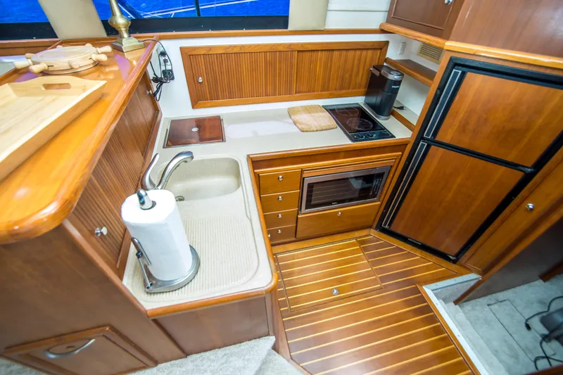 Play’n Hooky Yacht Photos Pics Luxurious 1999 Riviera 43 Open Flybridge yacht kitchen with wood cabinetry and modern appliances.