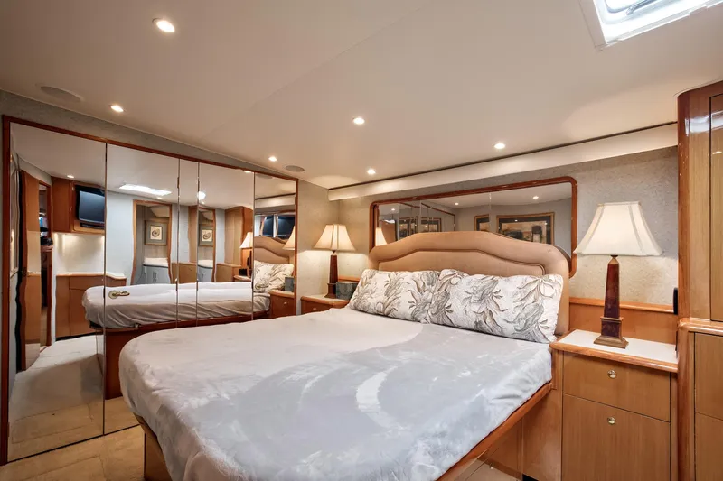 Good To Go Yacht Photos Pics Luxurious bedroom interior of a 2002 Viking 61 yacht with mirrored closets and elegant lighting.