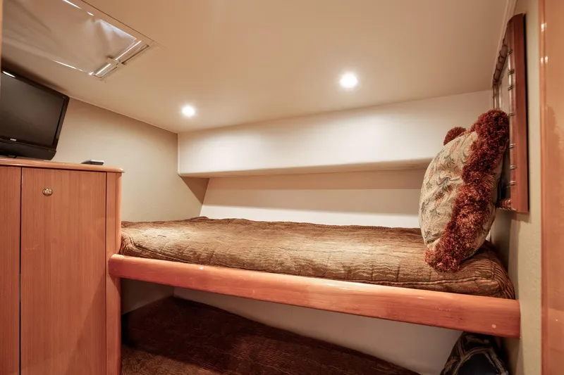 Good To Go Yacht Photos Pics Cozy cabin interior of 2002 Viking 61 yacht with bed, TV, and lighting.