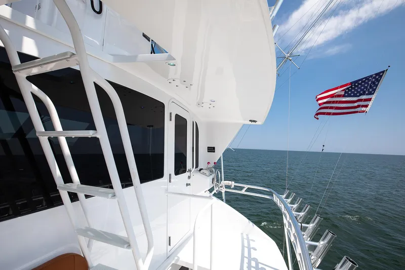 Good To Go Yacht Photos Pics 2002 Viking 61 yacht with American flag, ocean view, and clear blue sky.