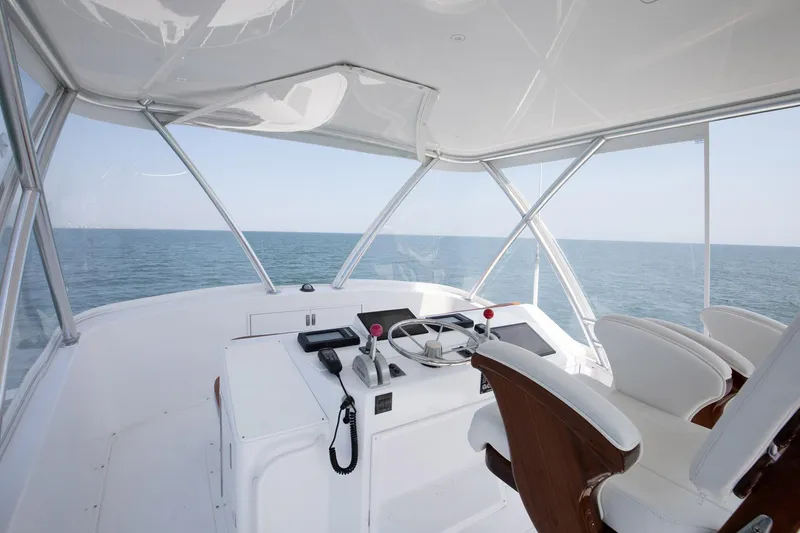 Good To Go Yacht Photos Pics Helm of 2002 Viking 61 yacht with ocean view, featuring steering wheel and controls.