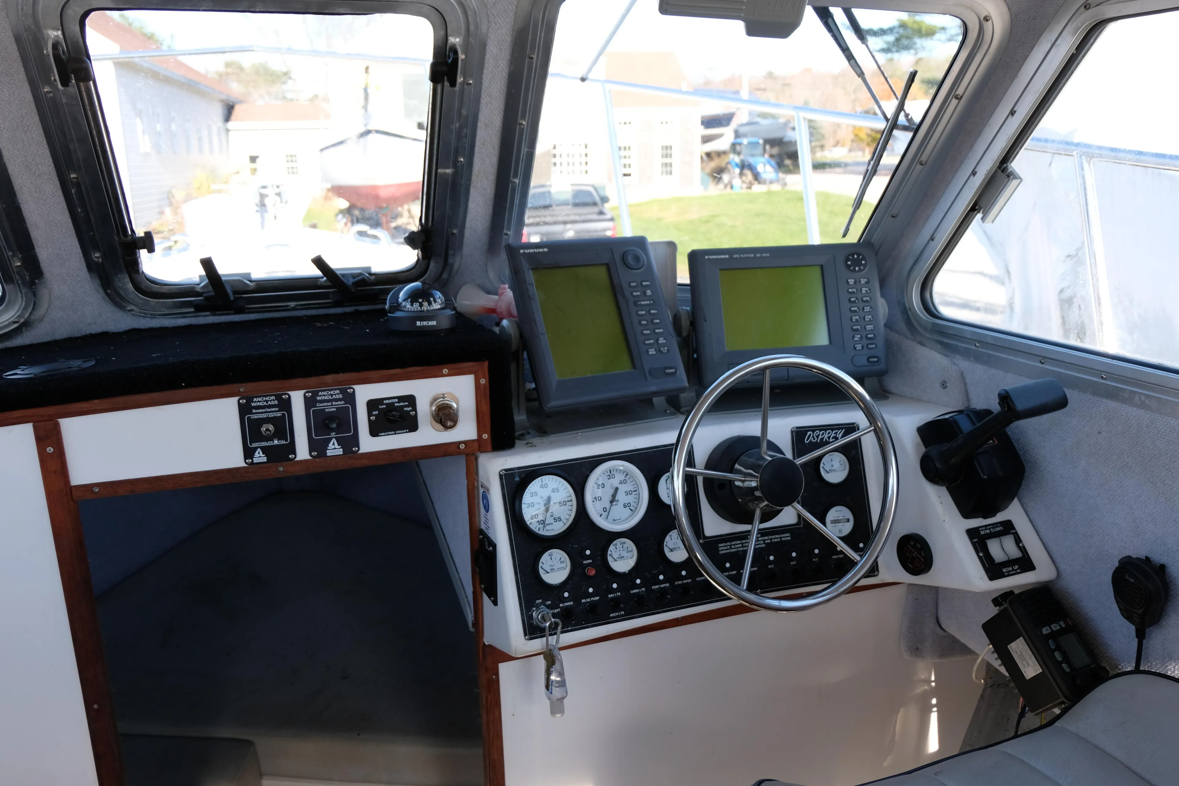 Interior of a 1999 Osprey 24 boat cockpit with navigation instruments and steering wheel.