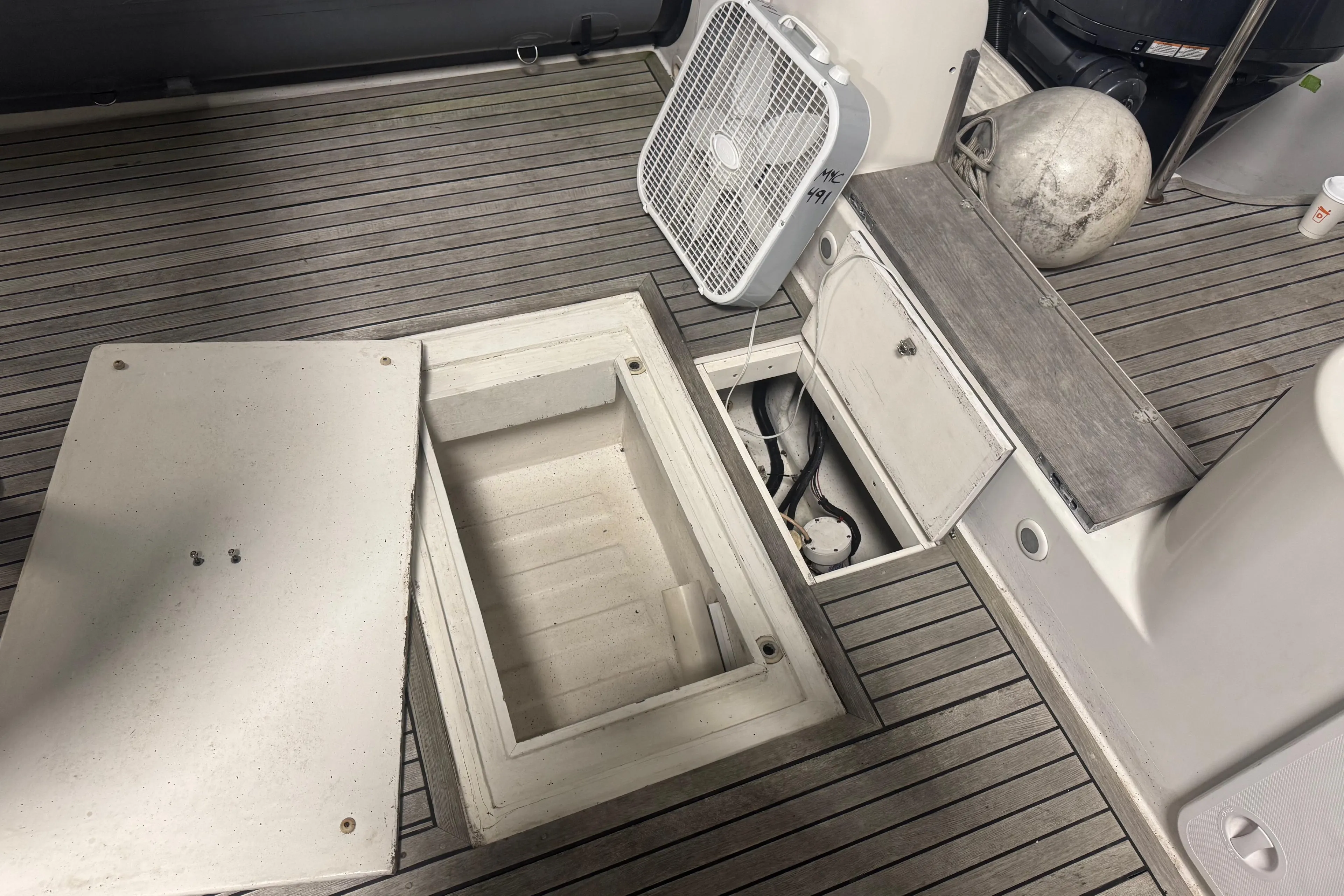 2016 Protector Tauranga 41 boat deck with open storage compartments and fan.