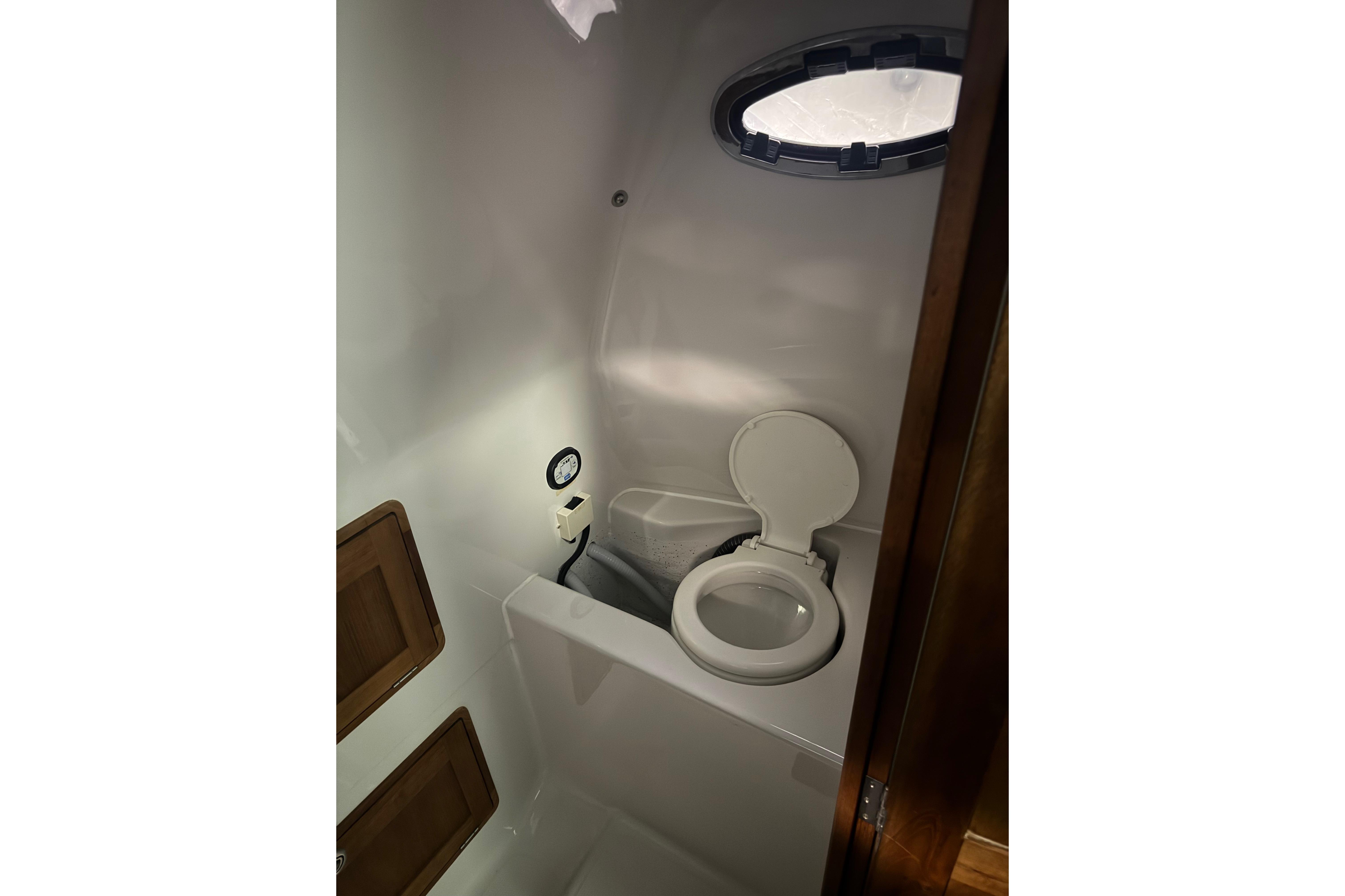 Bathroom interior of 2016 Protector Tauranga 41 boat, featuring a compact marine toilet.