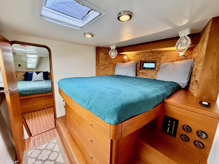 Starship Yacht Photos Pics Luxurious cabin interior of 2017 Gunboat 55 with cozy bed and wooden accents.