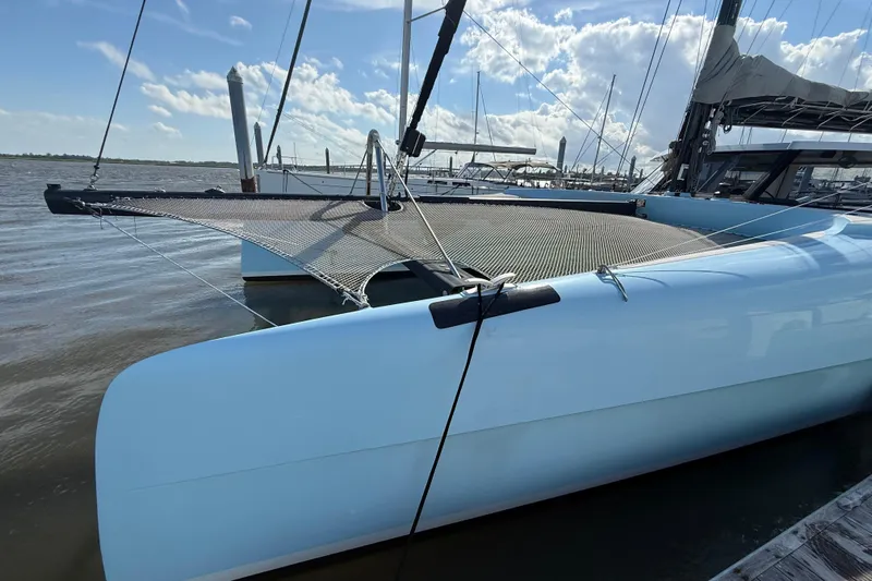 Starship Yacht Photos Pics 2017 Gunboat 55 catamaran docked, featuring sleek design and netted deck under blue sky.