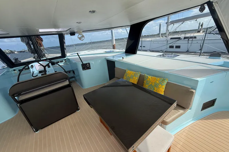 Starship Yacht Photos Pics 2017 Gunboat 55 yacht interior with helm, seating, and table, featuring vibrant cushions.