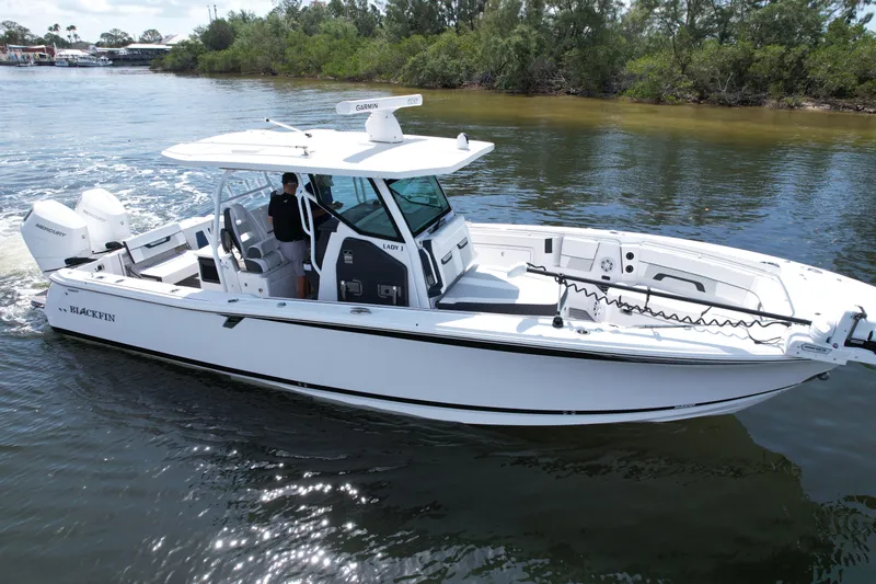  Yacht Photos Pics 2024 Blackfin 332 CC boat cruising on calm water, featuring sleek design and modern equipment.