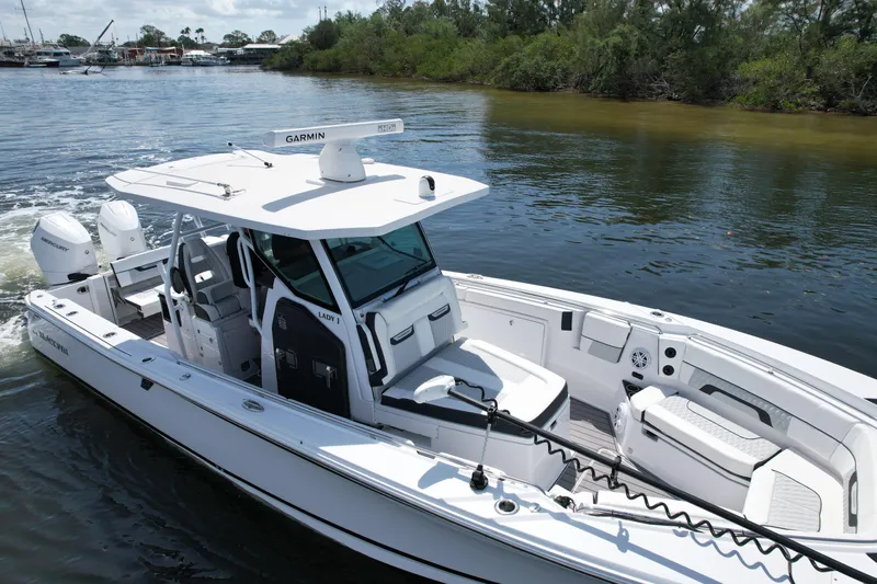  Yacht Photos Pics 2024 Blackfin 332 CC boat cruising on a calm river, featuring modern design and twin engines.