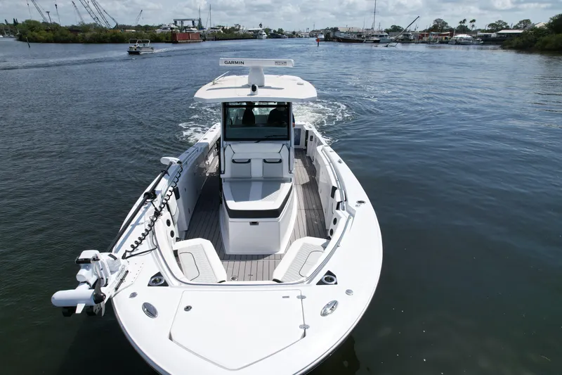  Yacht Photos Pics 2024 Blackfin 332 CC boat cruising on a calm waterway, showcasing sleek design and advanced features.