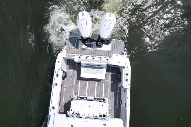  Yacht Photos Pics 2024 Blackfin 332 CC boat, aerial view, twin engines, sleek deck design, cruising on water.