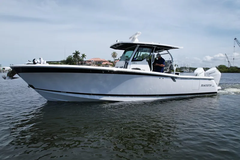  Yacht Photos Pics 2024 Blackfin 332 CC boat cruising on calm water under a clear sky.
