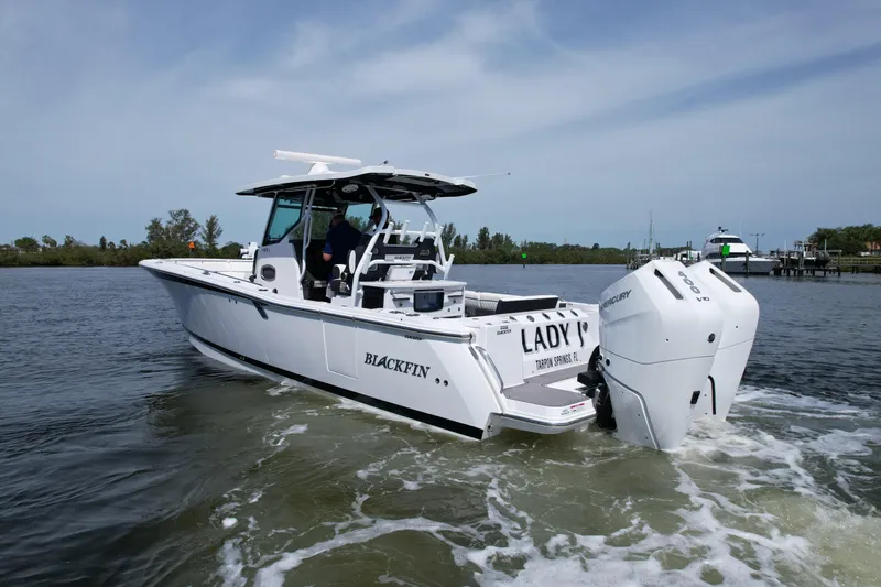  Yacht Photos Pics 2024 Blackfin 332 CC boat cruising on a calm waterway with twin Mercury engines.