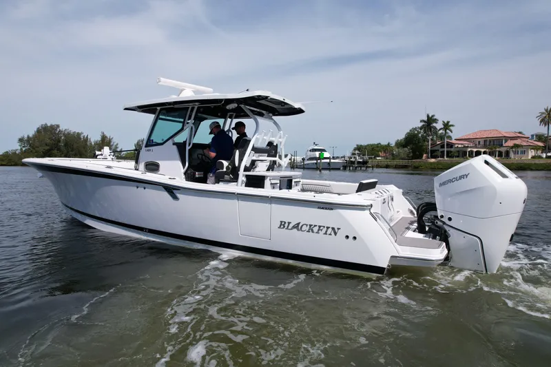  Yacht Photos Pics 2024 Blackfin 332 CC boat cruising on water, featuring sleek design and powerful Mercury engine.