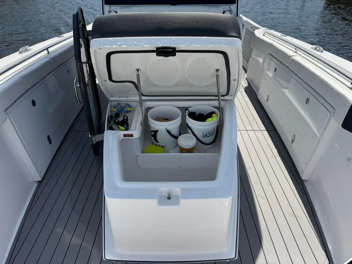  Yacht Photos Pics 2024 Blackfin 332 CC boat storage compartment with open lid, revealing buckets and gear.